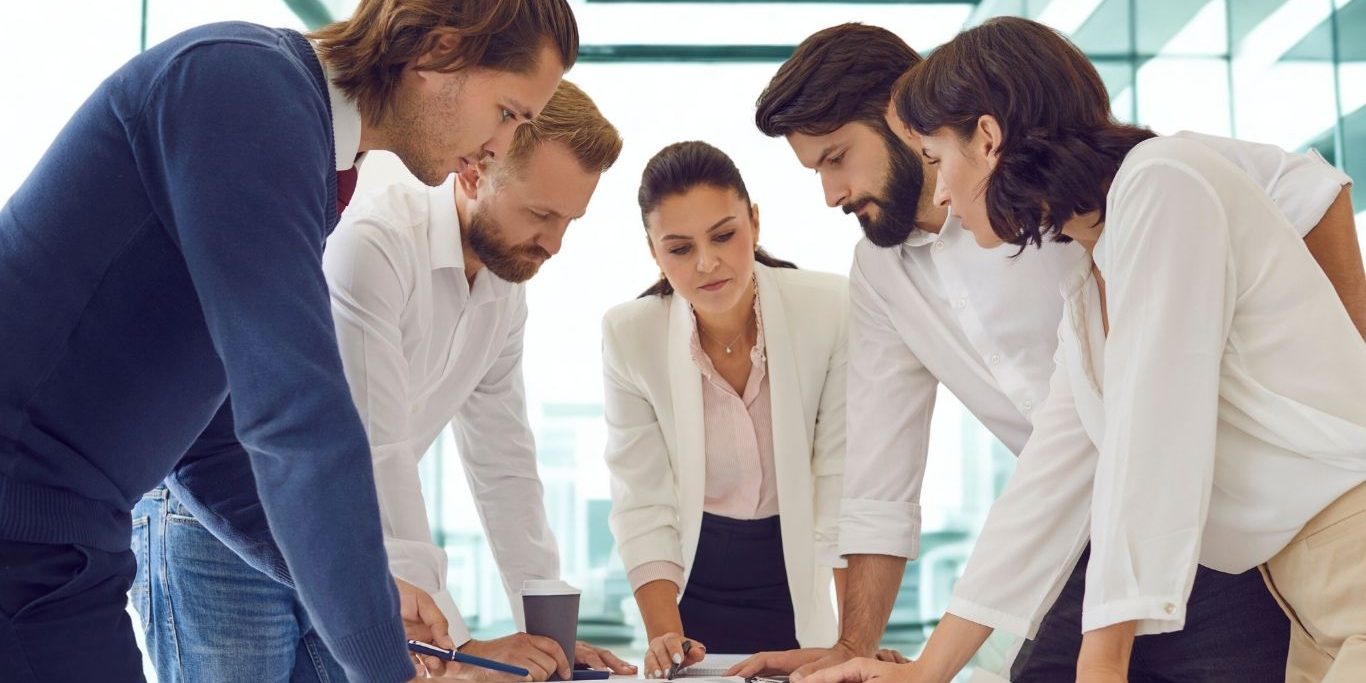 Equipo directivo revisando estrategia de comunicación post-vacaciones para aumentar visibilidad de marca B2B.