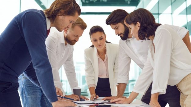 Equipo directivo revisando estrategia de comunicación post-vacaciones para aumentar visibilidad de marca B2B.